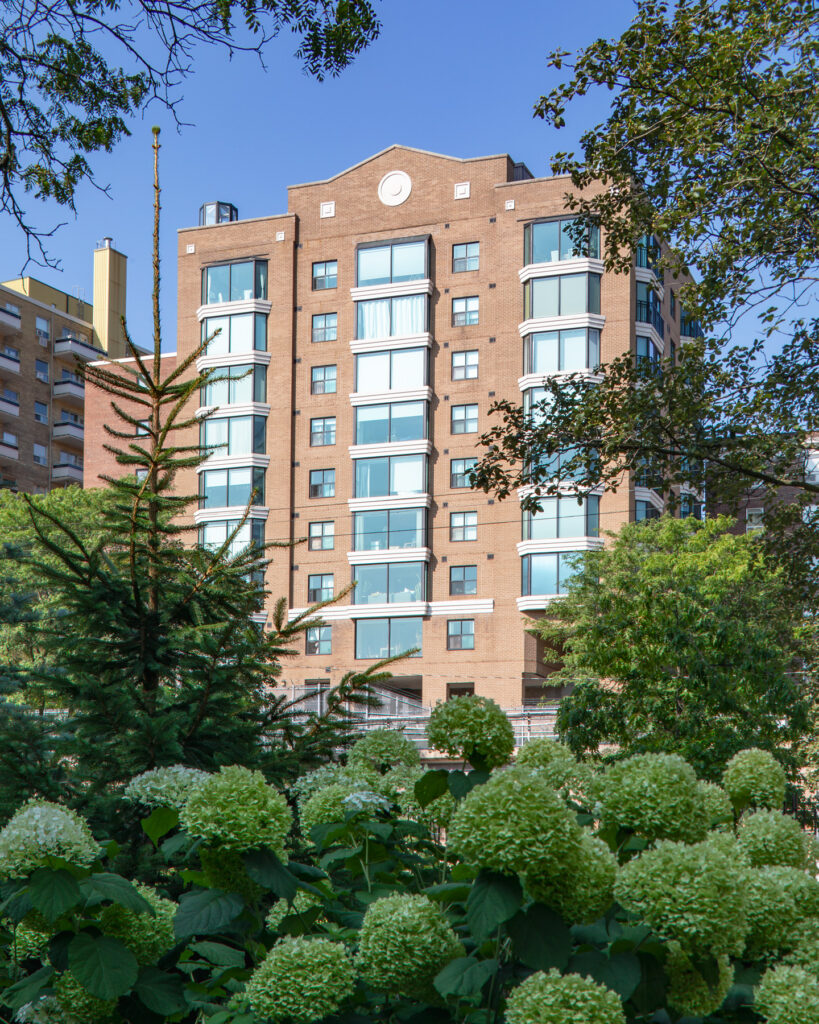 A view of 97 Lawton with trees in front of it during the day